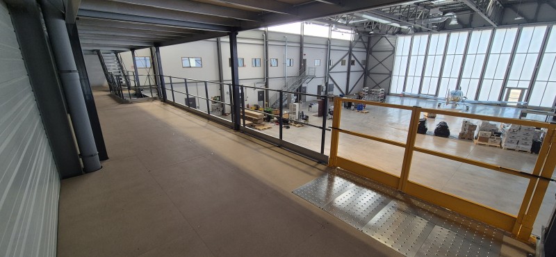 Mezzanine de stockage deux niveaux dans un atelier de maintenance aéronautique avec optimisation de la hauteur disponible, fabrication personnalisée et installation rapide à proximité de Lyon.