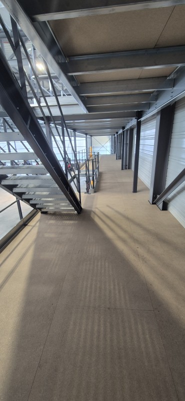 Mezzanine de stockage deux niveaux dans un atelier de maintenance aéronautique avec optimisation de la hauteur disponible, fabrication personnalisée et installation rapide à proximité de Lyon.