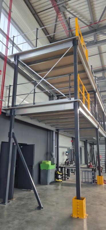 Mezzanine de stockage deux niveaux dans un atelier de maintenance aéronautique avec optimisation de la hauteur disponible, fabrication personnalisée et installation rapide à proximité de Lyon.