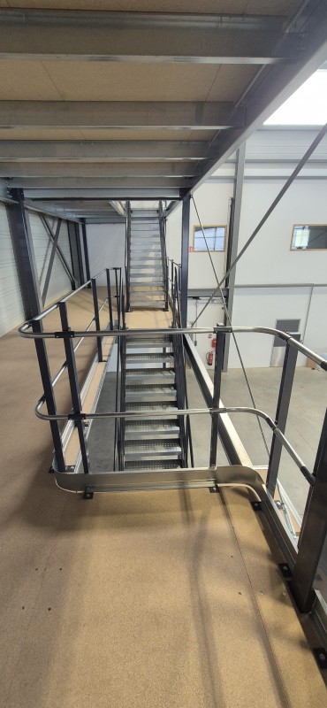 Mezzanine de stockage deux niveaux dans un atelier de maintenance aéronautique avec optimisation de la hauteur disponible, fabrication personnalisée et installation rapide à proximité de Lyon.