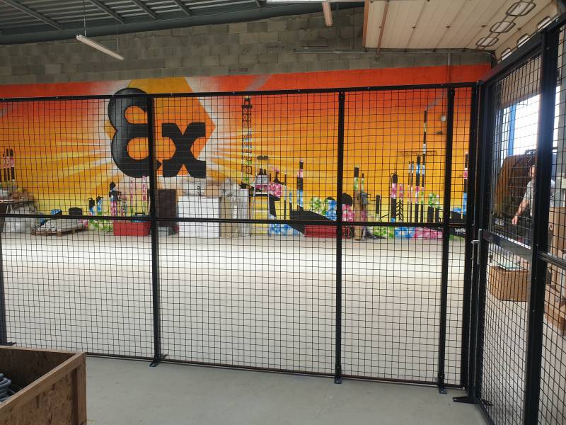 Cloison grillagée industrielle avec porte battante pour la délimitation et la sécurisation d'une zone de stockage à Genay