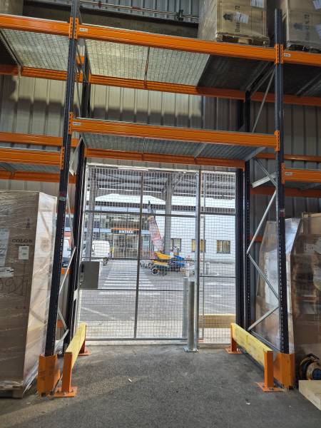 Porte coulissante grillagée grande hauteur pour contrôler l'acces à un atelier de découpe dans une grande surface de bricolage à Lyon