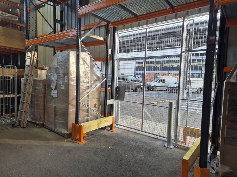 Porte coulissante grillagée grande hauteur pour contrôler l'acces à un atelier de découpe dans une grande surface de bricolage à Lyon
