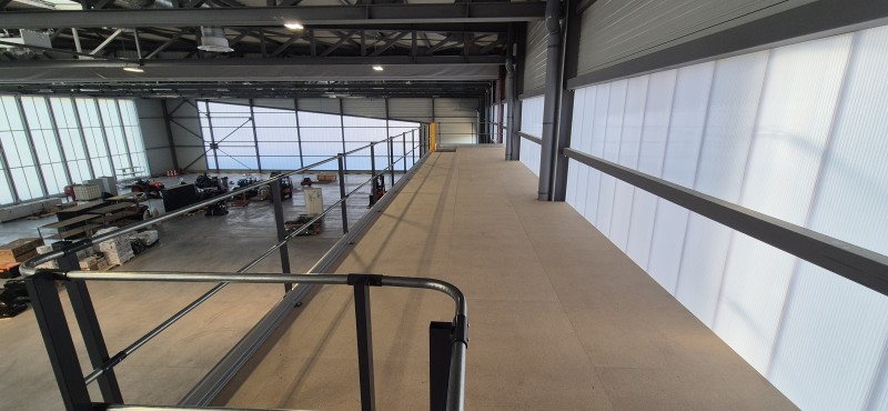 Mezzanine de stockage deux niveaux dans un atelier de maintenance aéronautique avec optimisation de la hauteur disponible, fabrication personnalisée et installation rapide à proximité de Lyon.