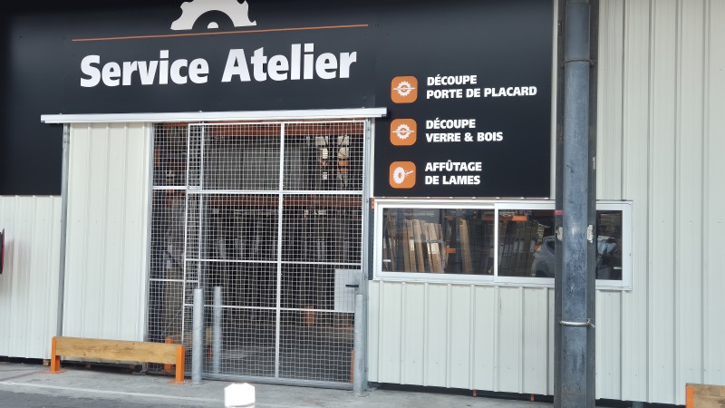 Porte coulissante grillagée grande hauteur pour contrôler l'acces à un atelier de découpe dans une grande surface de bricolage à Lyon